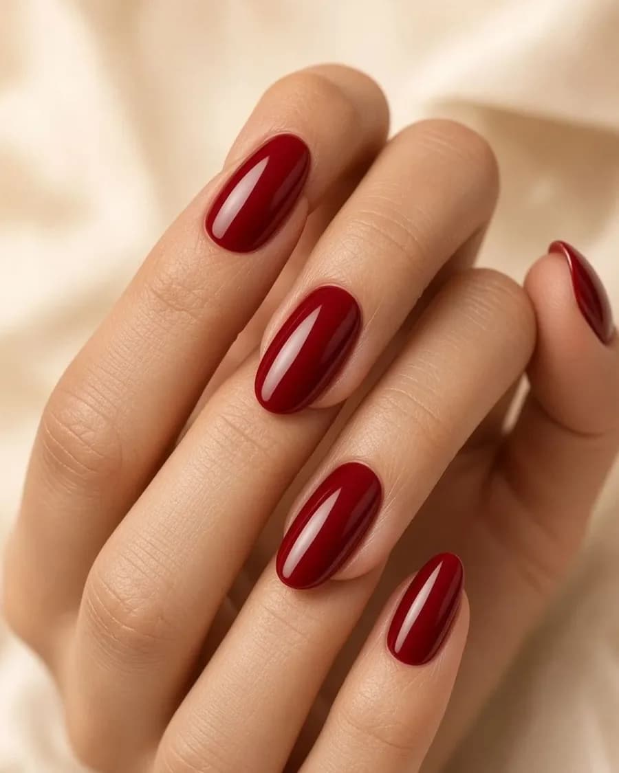 Glossy deep rose manicure in warm salon light